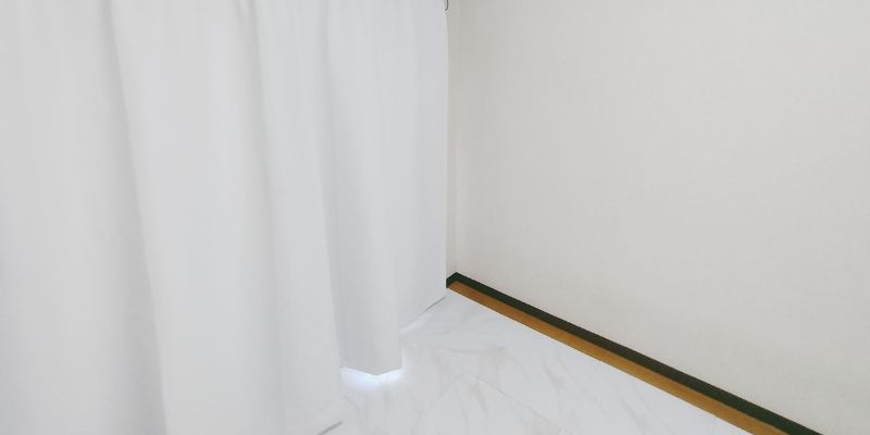 部屋の全体像引き写真:狭い部屋でも余白を作ることで広く見えるカーテンと壁